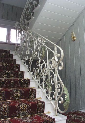 schody wewnętrzna z bogato zdobioną balustradą kutą