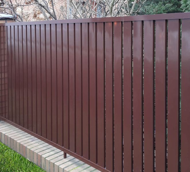 brązowe ogrodzenie typu palisada pionowa